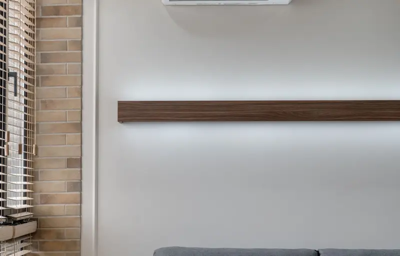Split air-conditioning indoor unit above the sofa in a bright, minimal living room